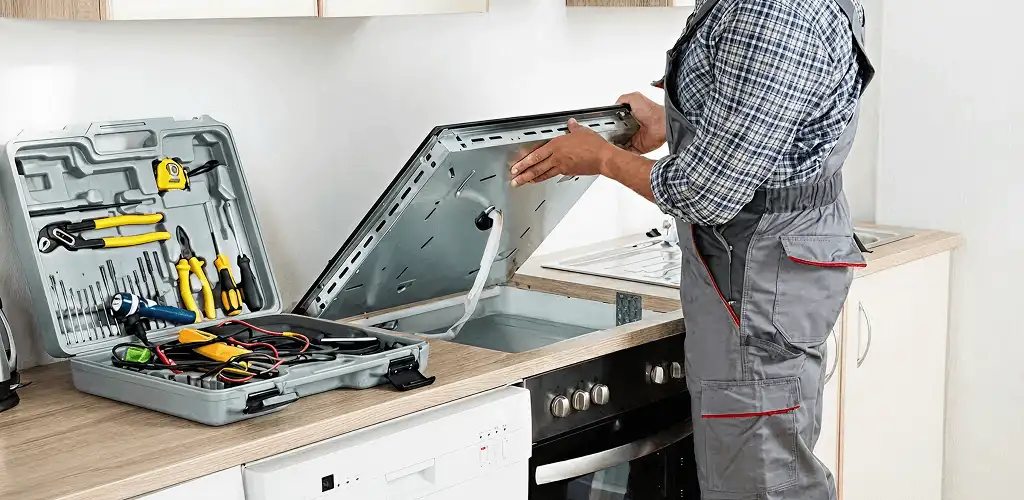 Handyman repairing a cooktop and checking wiring connections in Columbia, SC