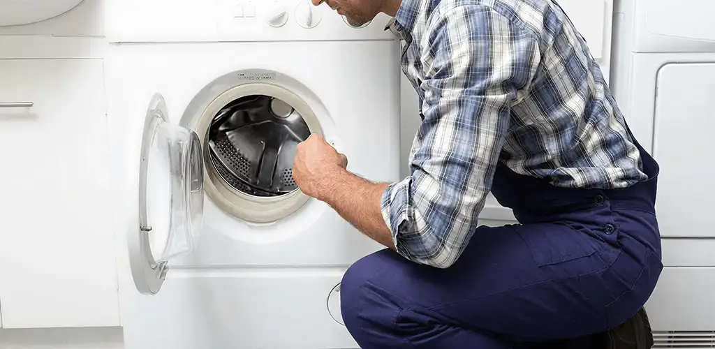 Handyman inspecting a dryer drum and internal parts for repair in Columbia, SC