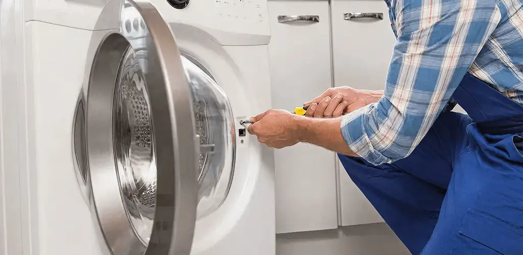 Handyman repairing a clothes dryer and checking electrical connections in Columbia, SC