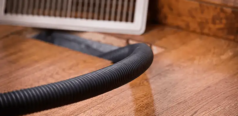 Air duct cleaning hose inserted into a floor vent for ductwork cleaning in Columbia, SC