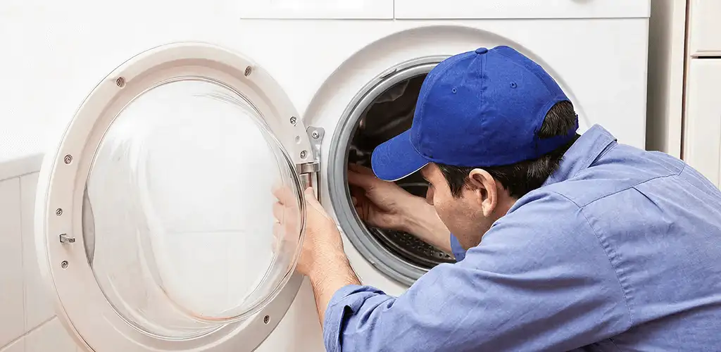 Washing machine repair handyman inspecting a front-load washer drum in Columbia, SC